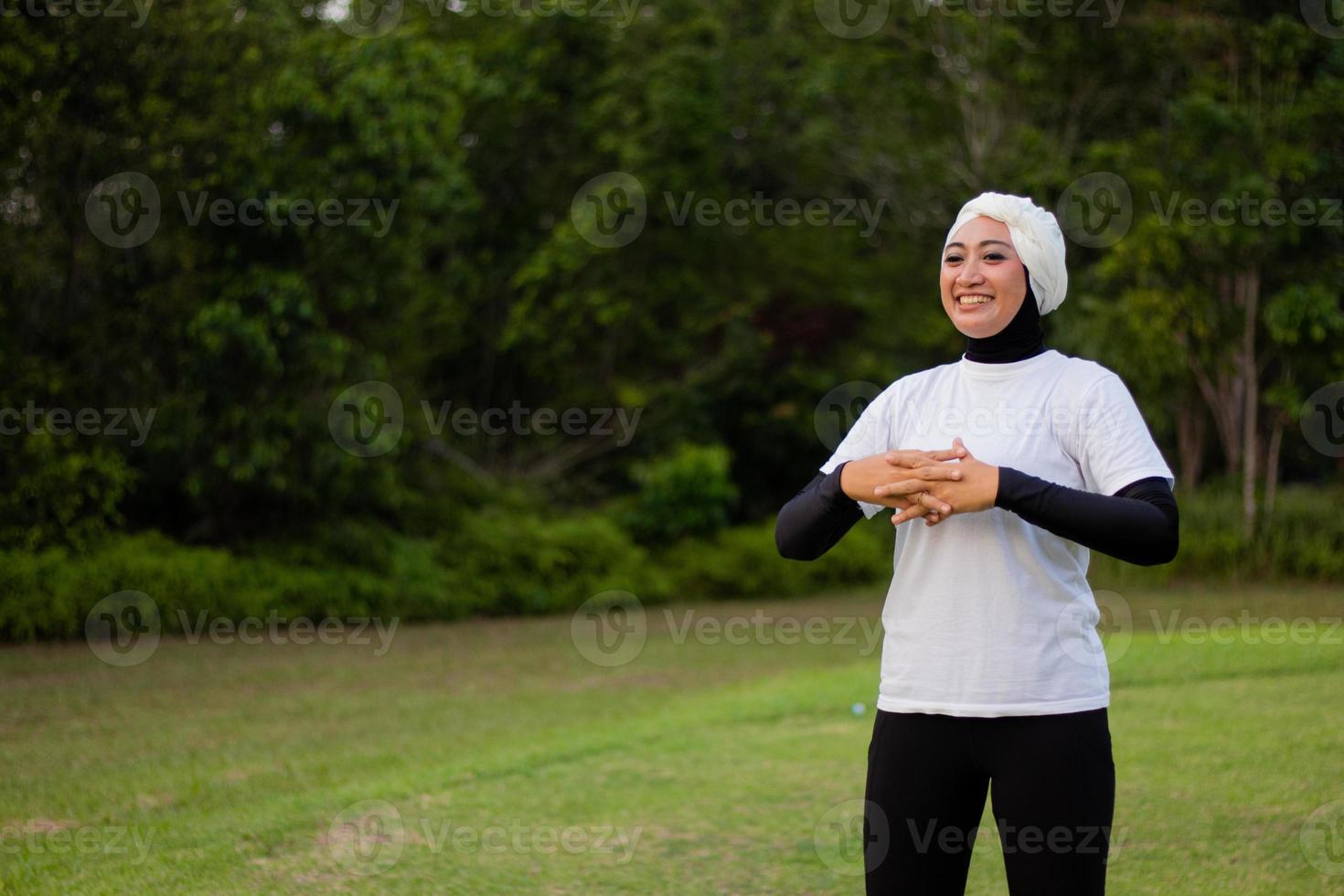 mujer agradable en hijab y ropa deportiva haciendo yoga y estiramiento. foto