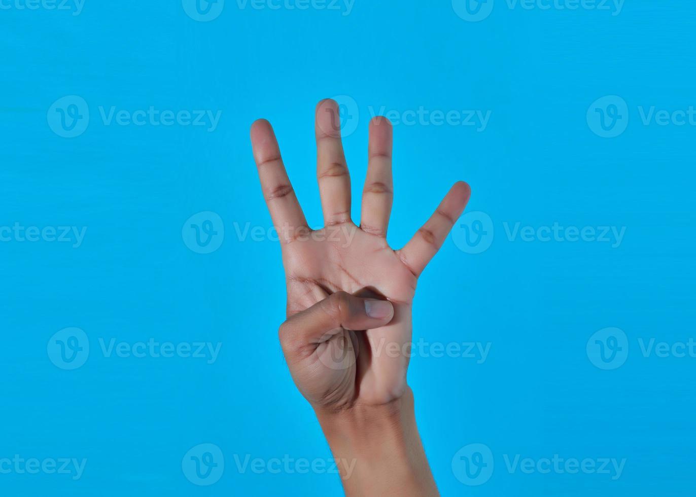 closeup hand showing number four 4 with hand. blue background. photo