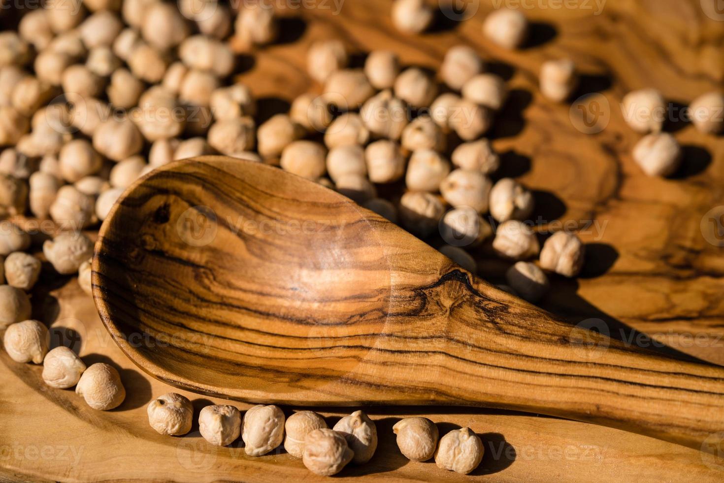 a pile of chick peas and a wooden spoon photo