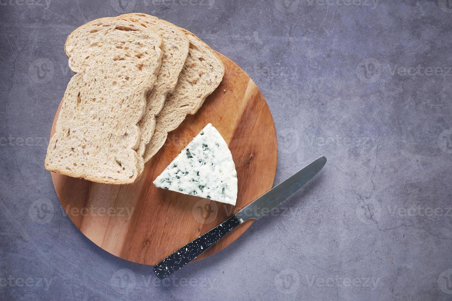 top view of blue cheese ,and slice of brown bread on table photo