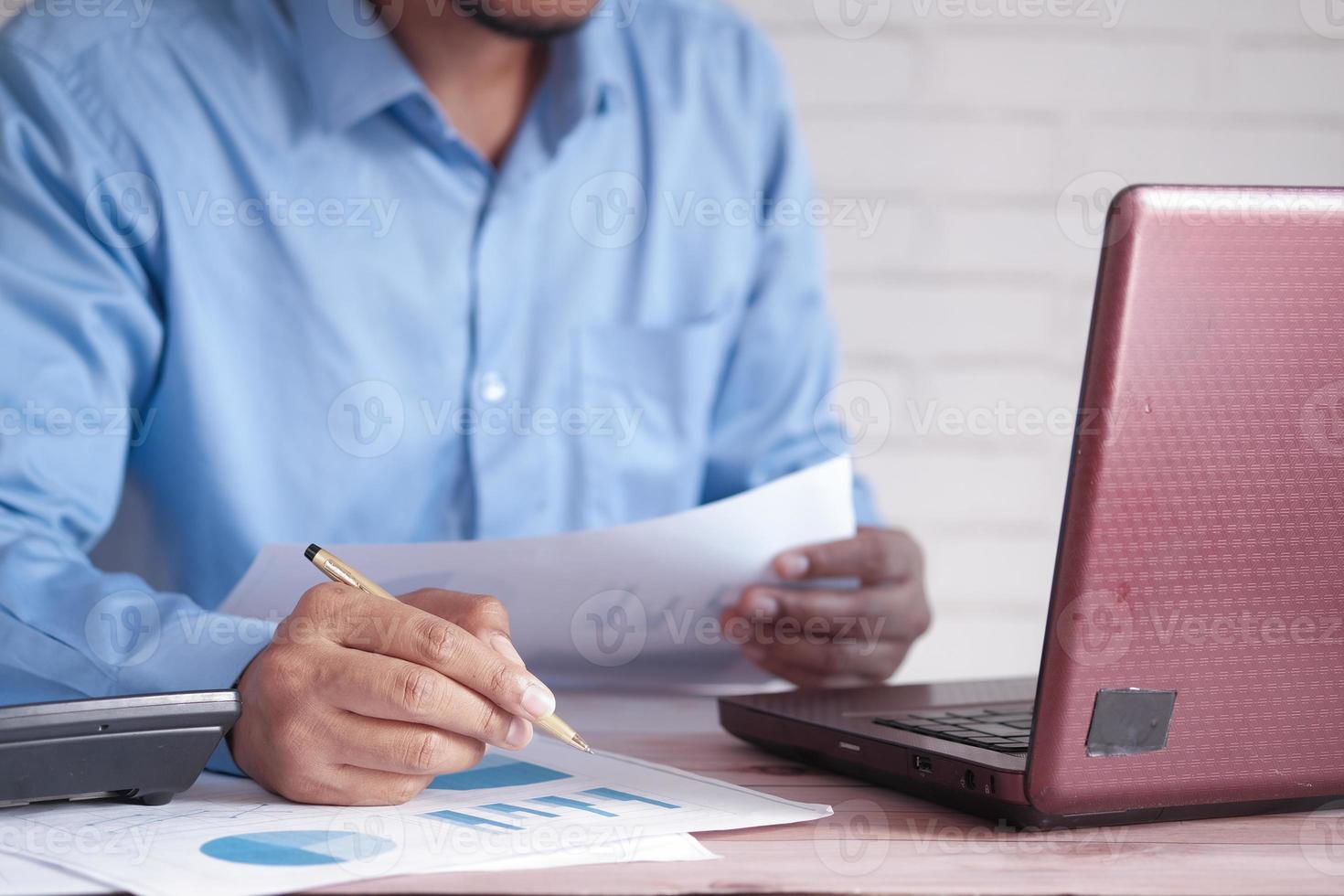 man hand with pen analyzing bar chart on paper photo