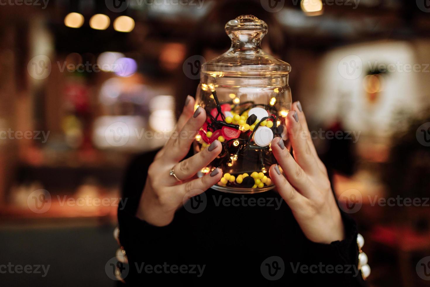 Young woman showing bottle of medicine. colored capsules photo