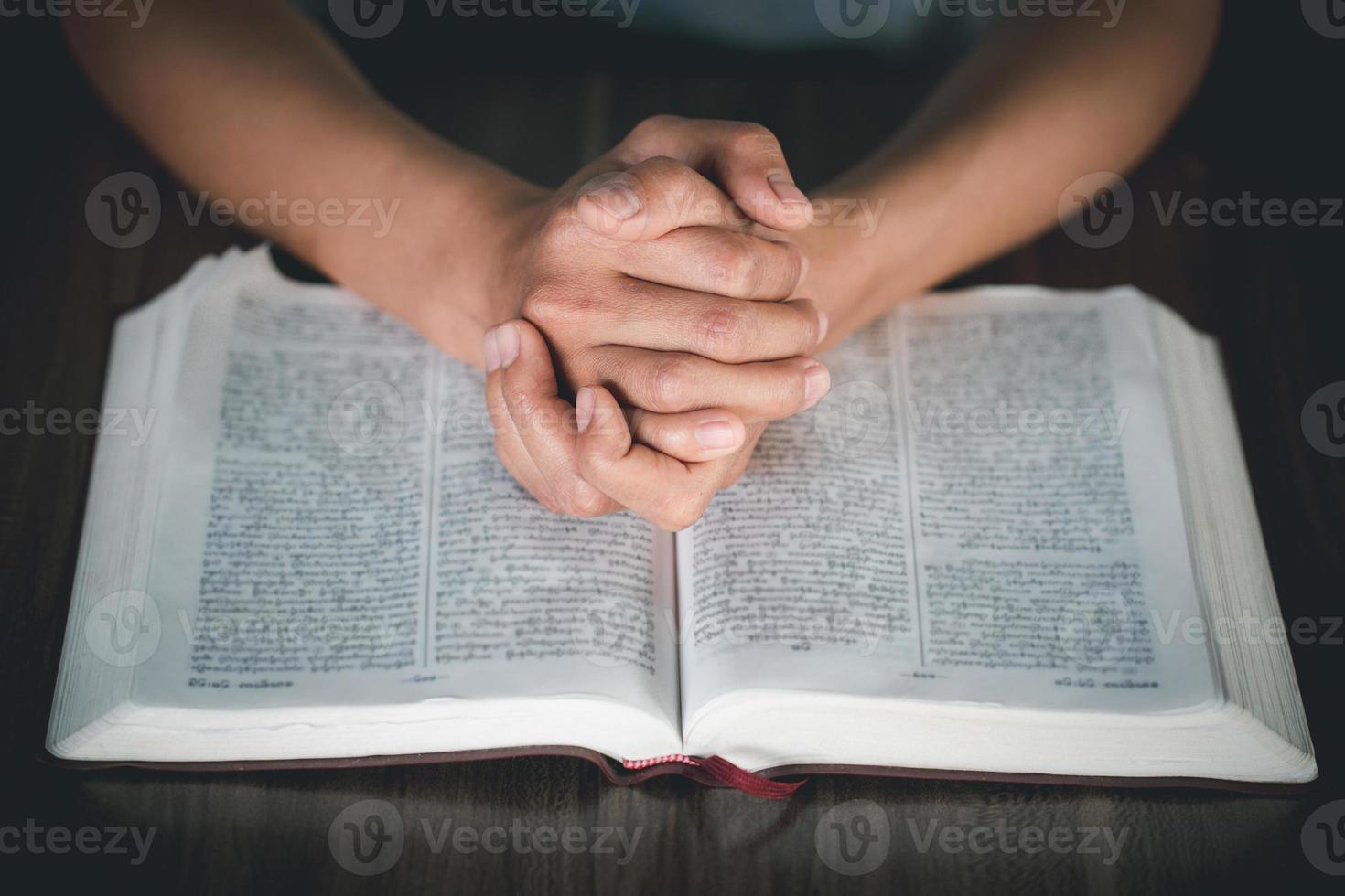 manos de mujer rezando a dios con la biblia foto