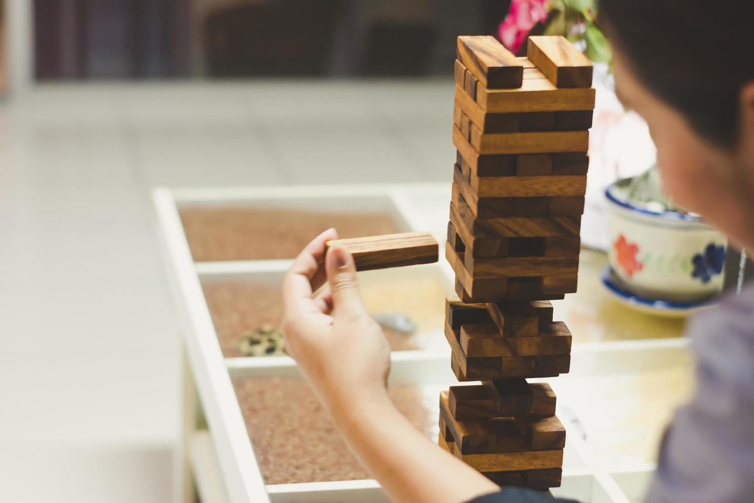 cerrar mujer jugando jenga block. para el concepto de éxito empresarial foto