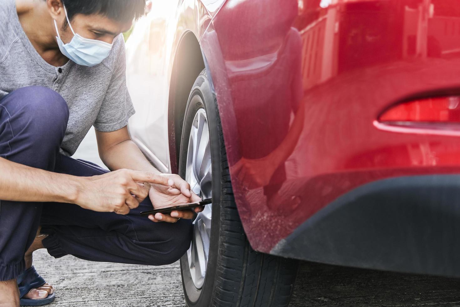 Hombre asiático medida de inspección de automóviles cantidad de caucho inflado foto