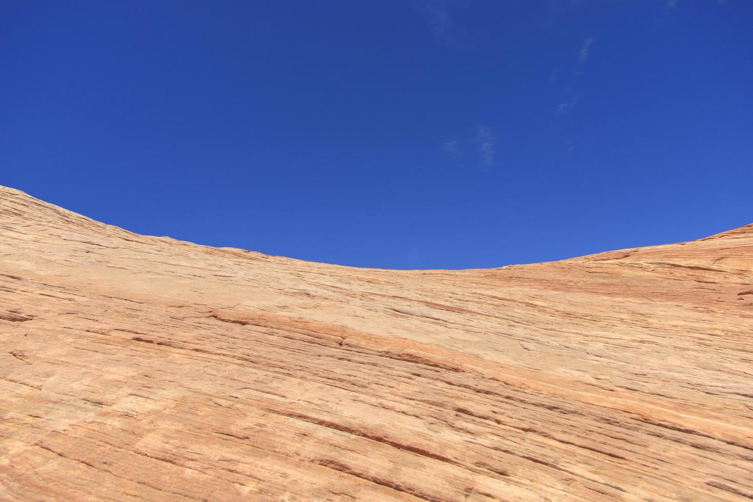 Blue sky behind a colorful sandstone rock in the desert photo