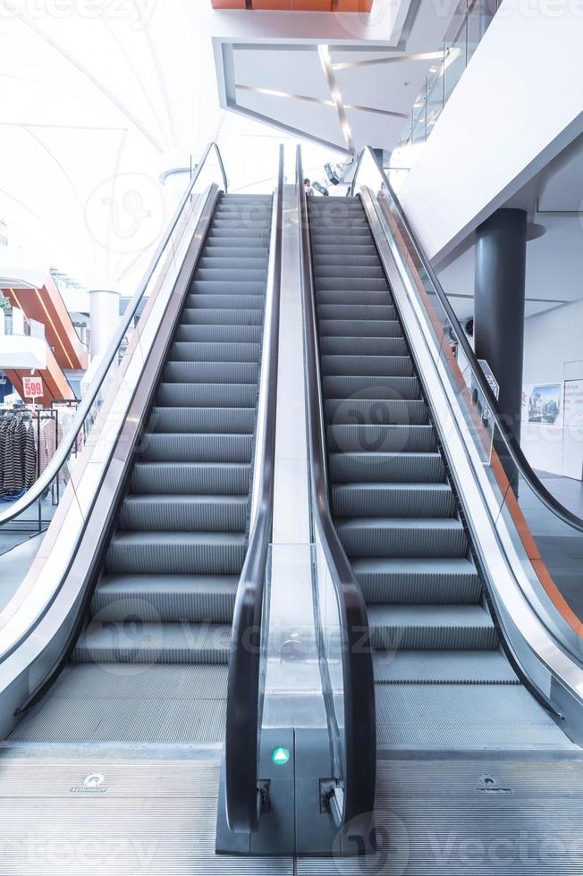 Escaleras mecánicas, subir y bajar escaleras mecánicas en edificio público. foto