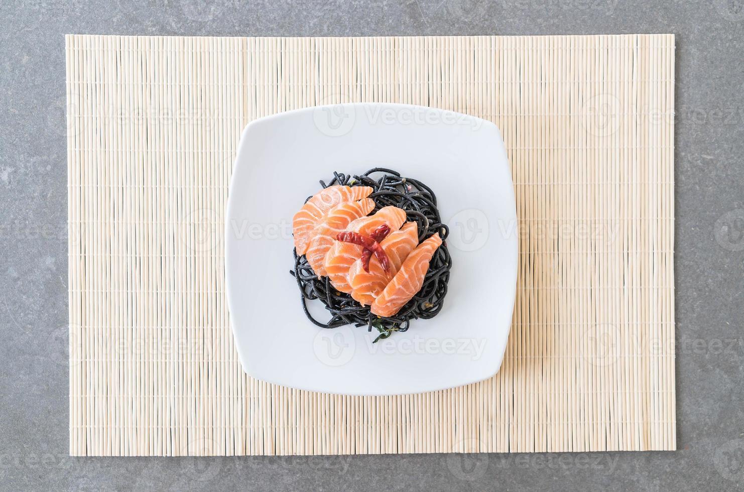 Spicy black spaghetti with salmon - fusion food style photo