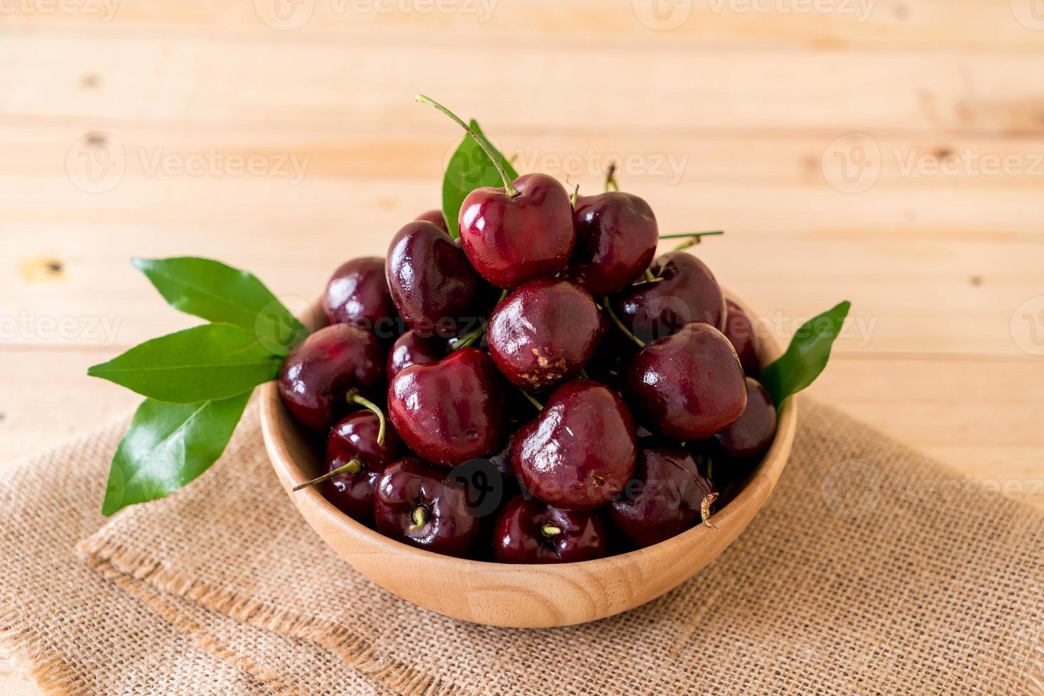 Fresh cherry in wood bowl on the table photo