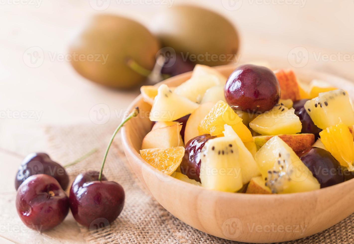 Mixed sliced fruit in wood plate photo