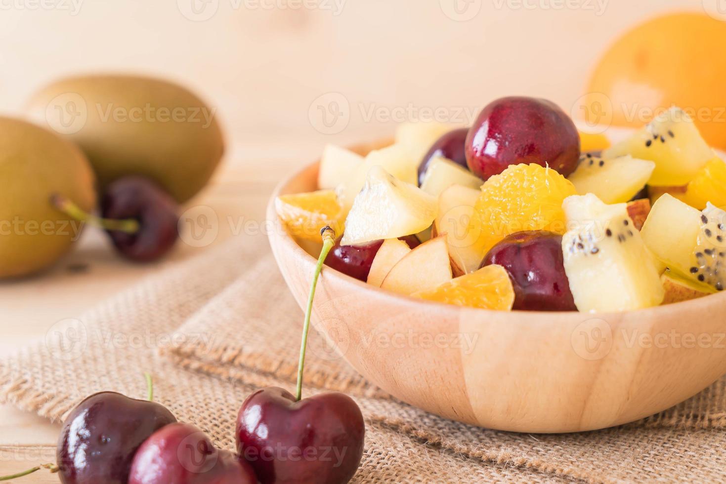 Mixed sliced fruit in wood plate photo