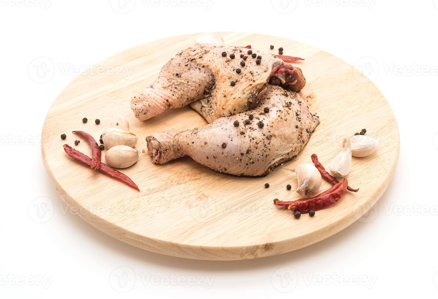 Marinated chicken thigh with sauce, black peppers, garlic, and dried chili on wood board photo