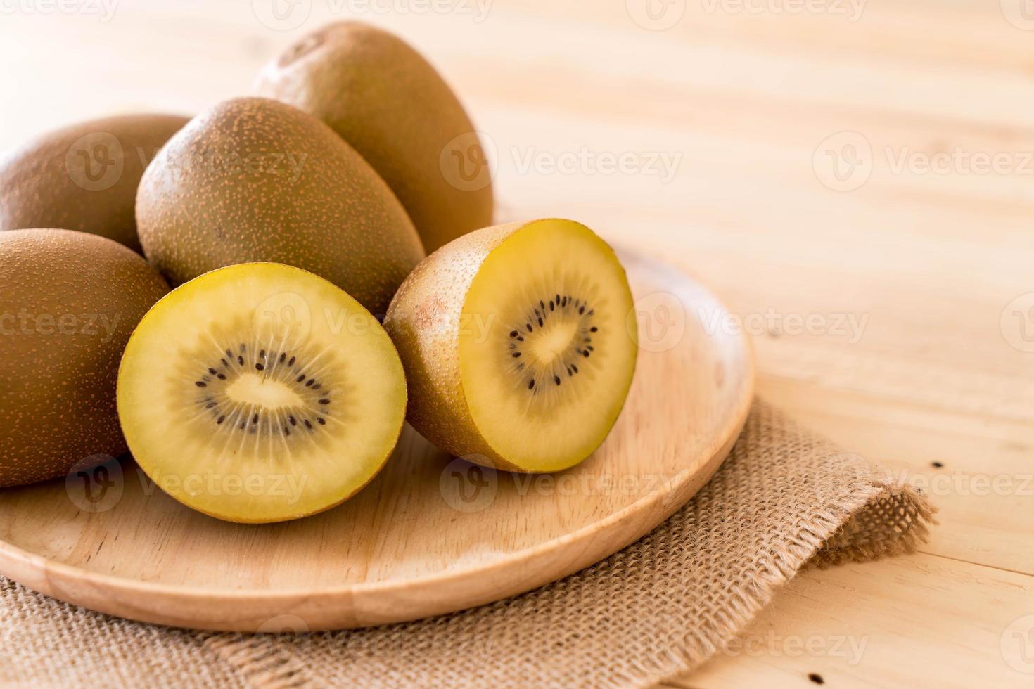 Fresh golden kiwi in wood plate photo