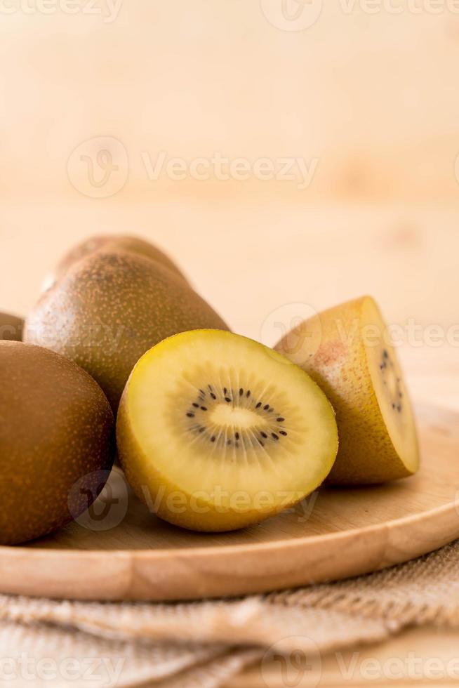 Fresh golden kiwi in wood plate photo