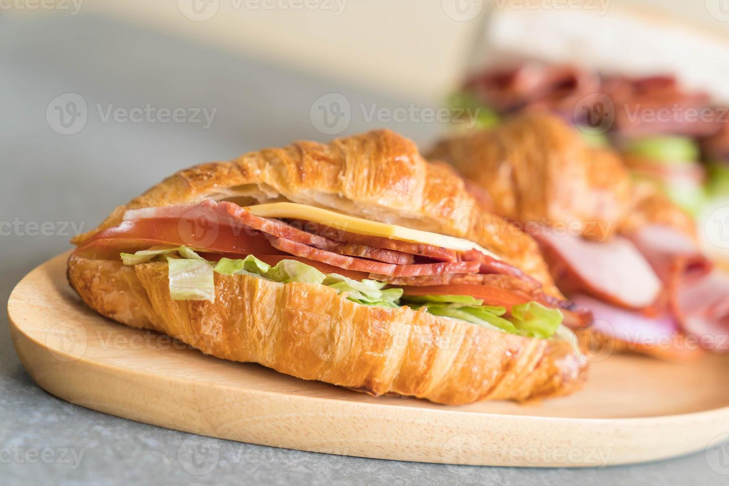 Jamón sándwich croissant en la mesa foto