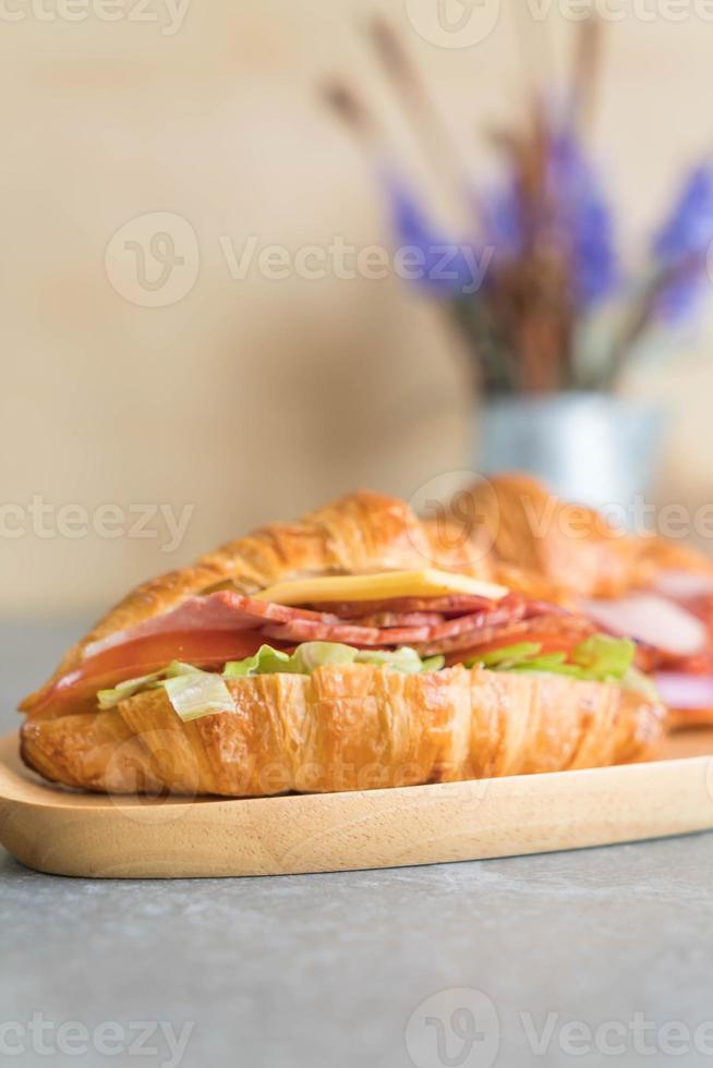 Jamón sándwich croissant en la mesa foto