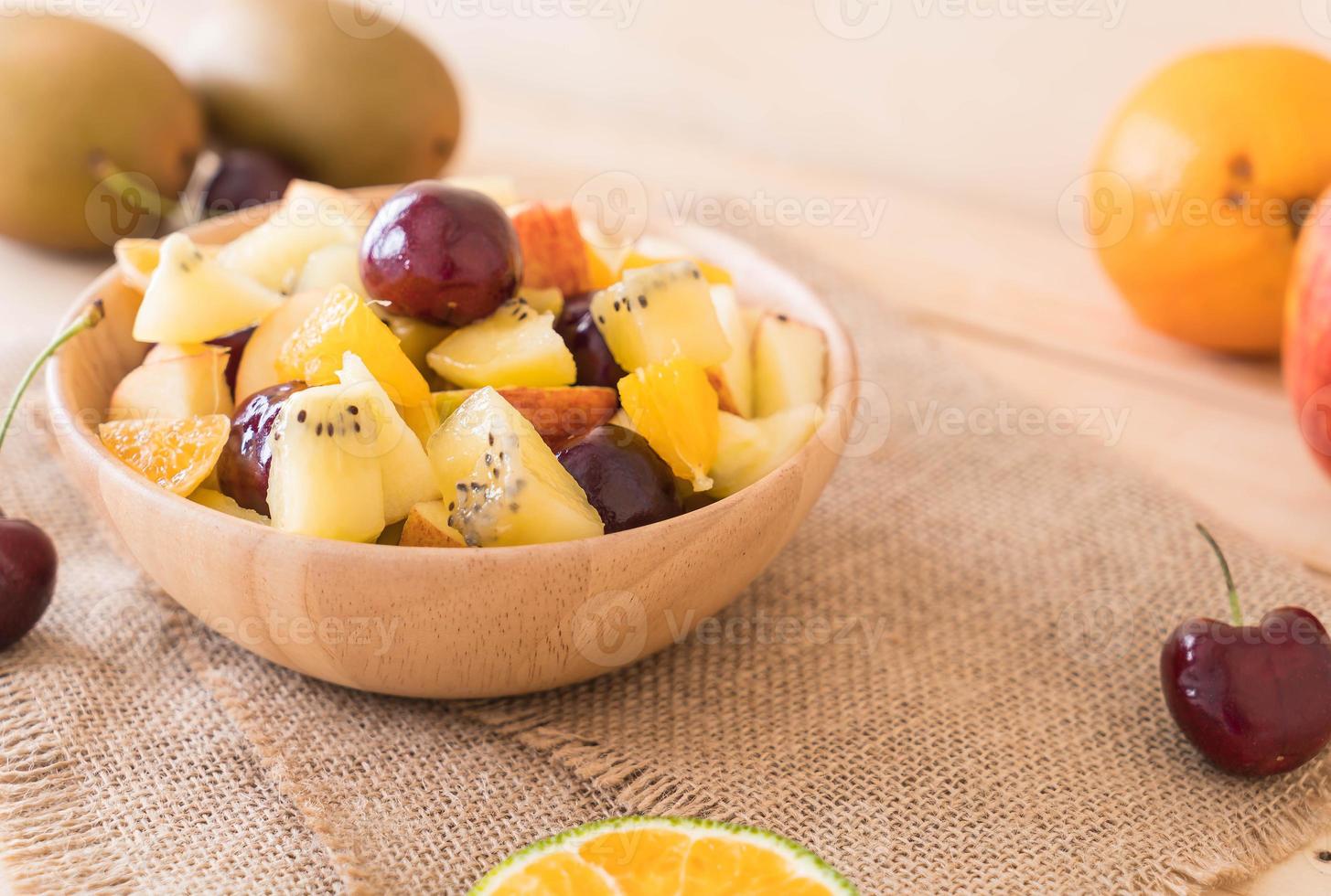 Fruta en rodajas mixtas en un tazón de madera foto