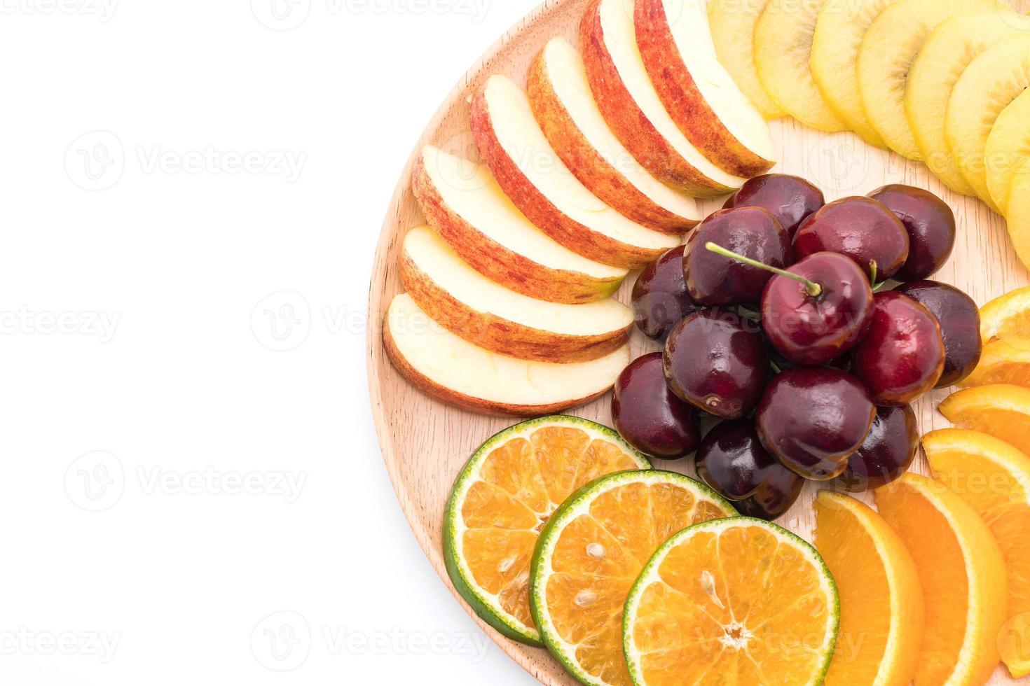 Mixed sliced fruit in wood plate photo