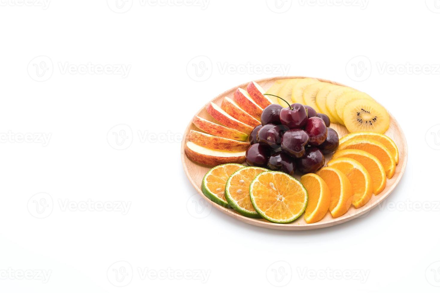 Fruta en rodajas mixtas en un tazón de madera foto