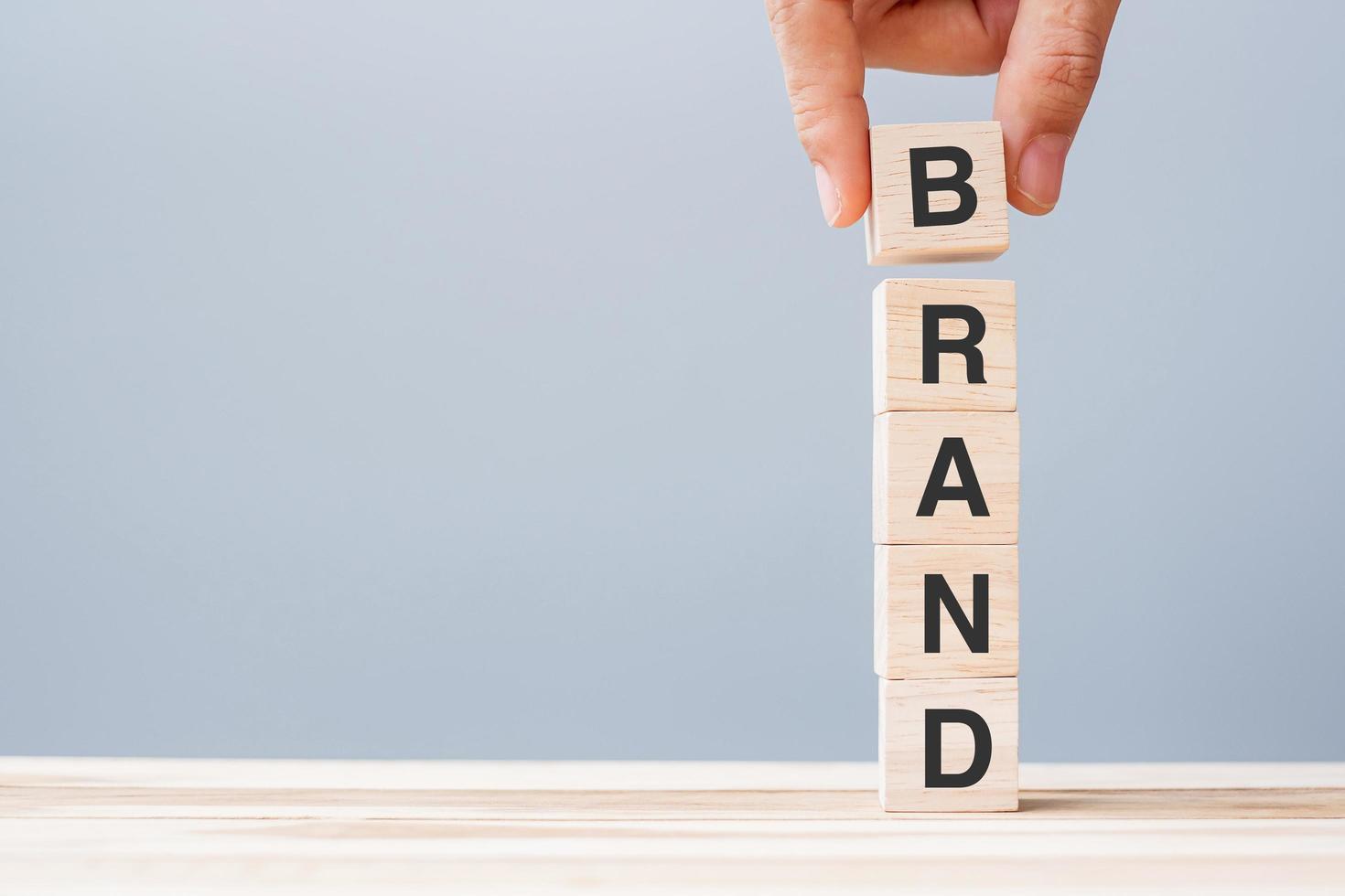 Hand holding wooden block with BRAND word photo