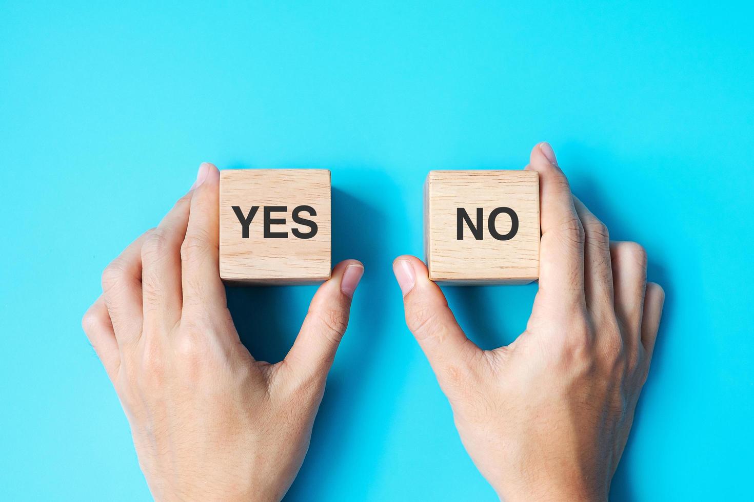 Hand choosing Yes or No block photo