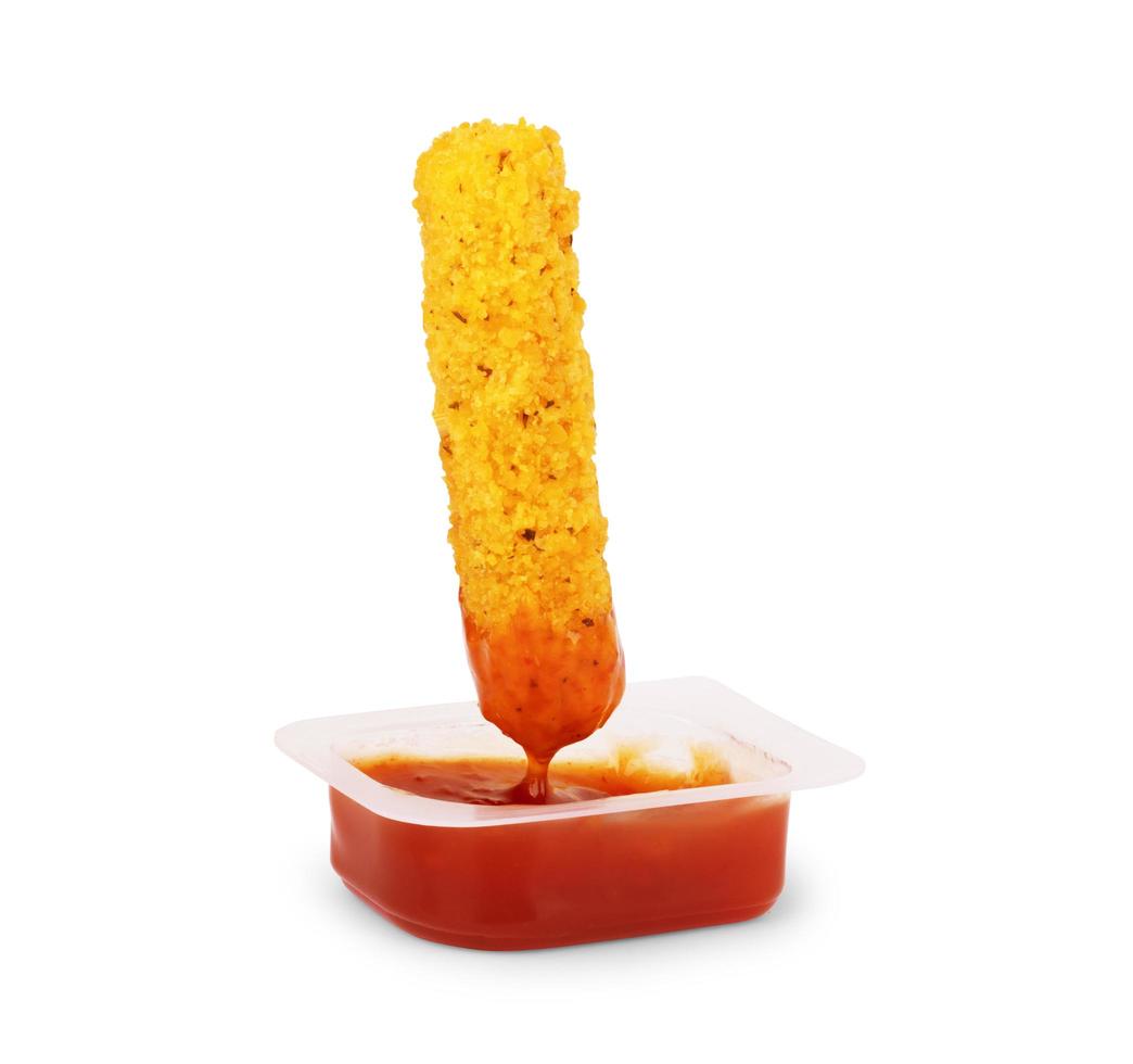 Sumergir sabrosas patatas fritas en salsa en un tazón, primer plano foto