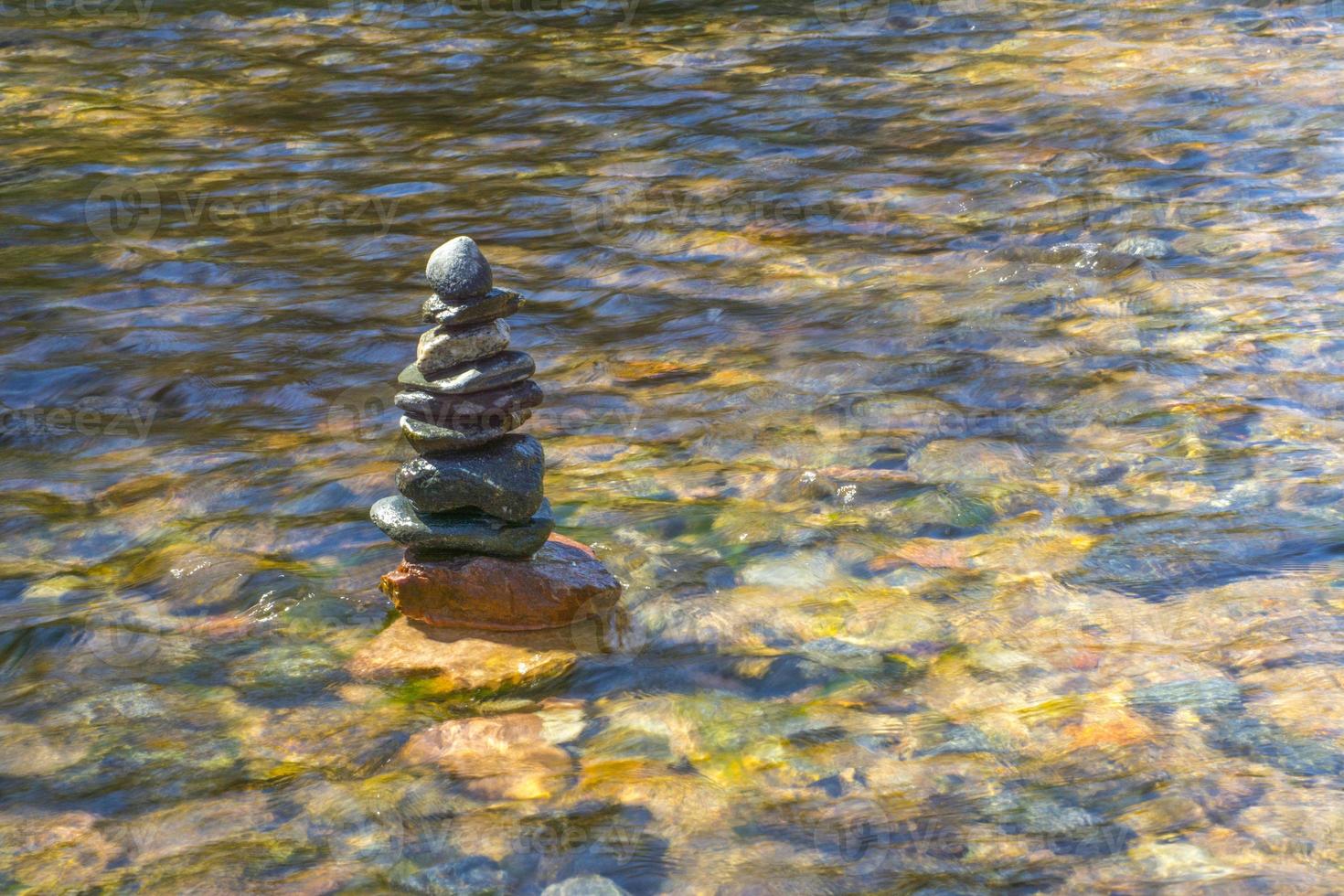 Pile of beautifully stacked stones in river photo