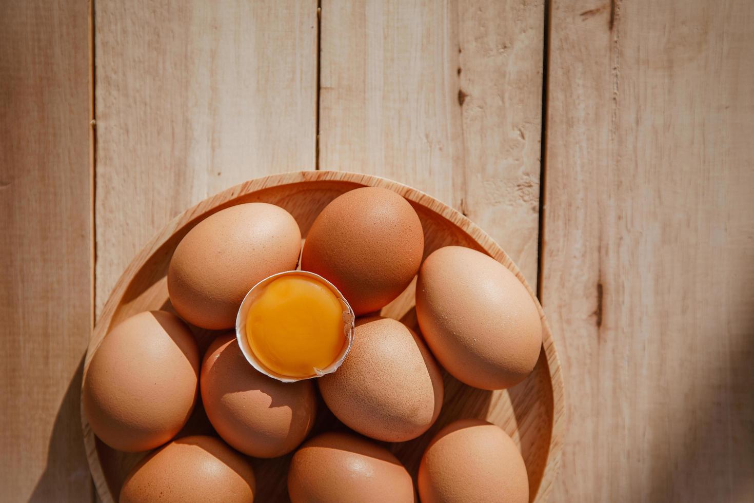 los huevos se ponen en bandejas de madera y tienen huevos rotos. foto