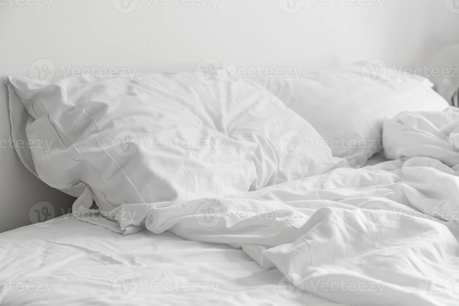 Cama con borde con decoración de almohada desordenada blanca en el interior del dormitorio foto