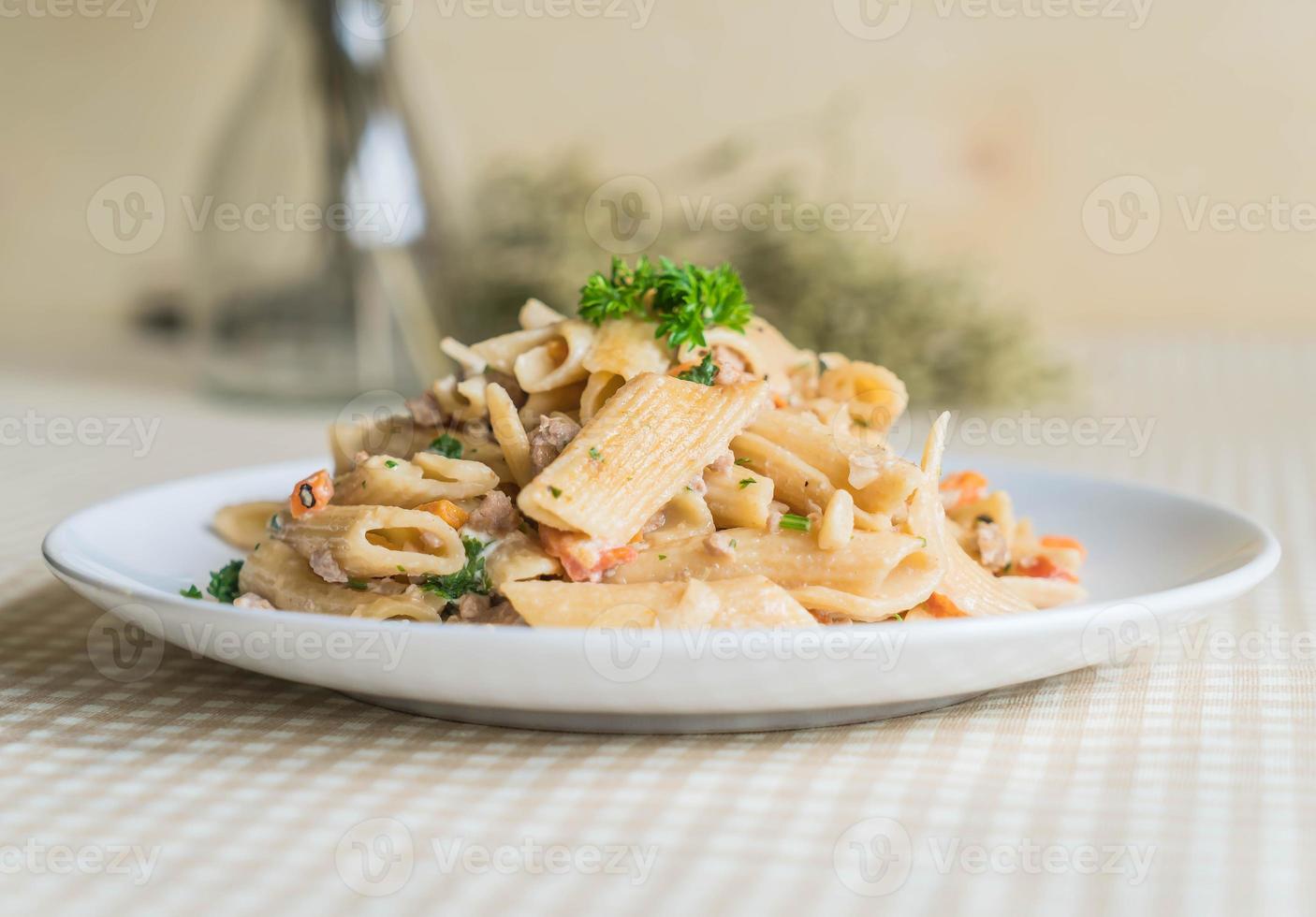 Pasta penne con queso crema en la mesa foto