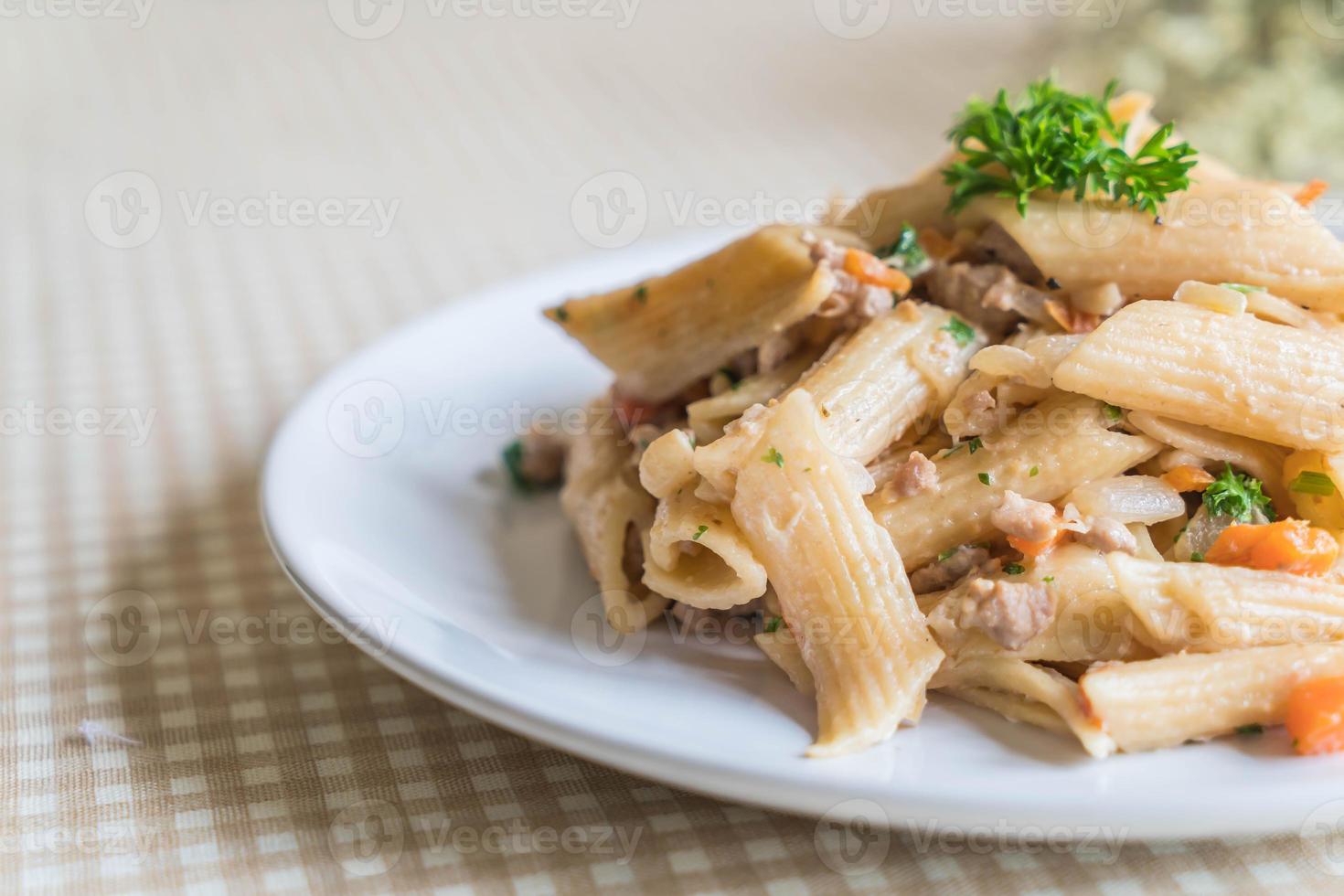 Pasta penne con queso crema en la mesa foto