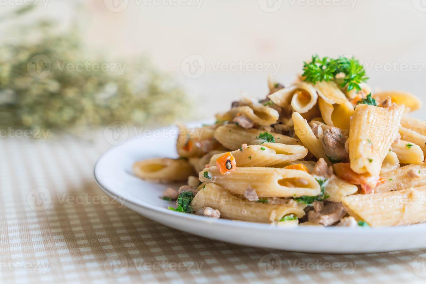 Pasta penne con queso crema en la mesa foto