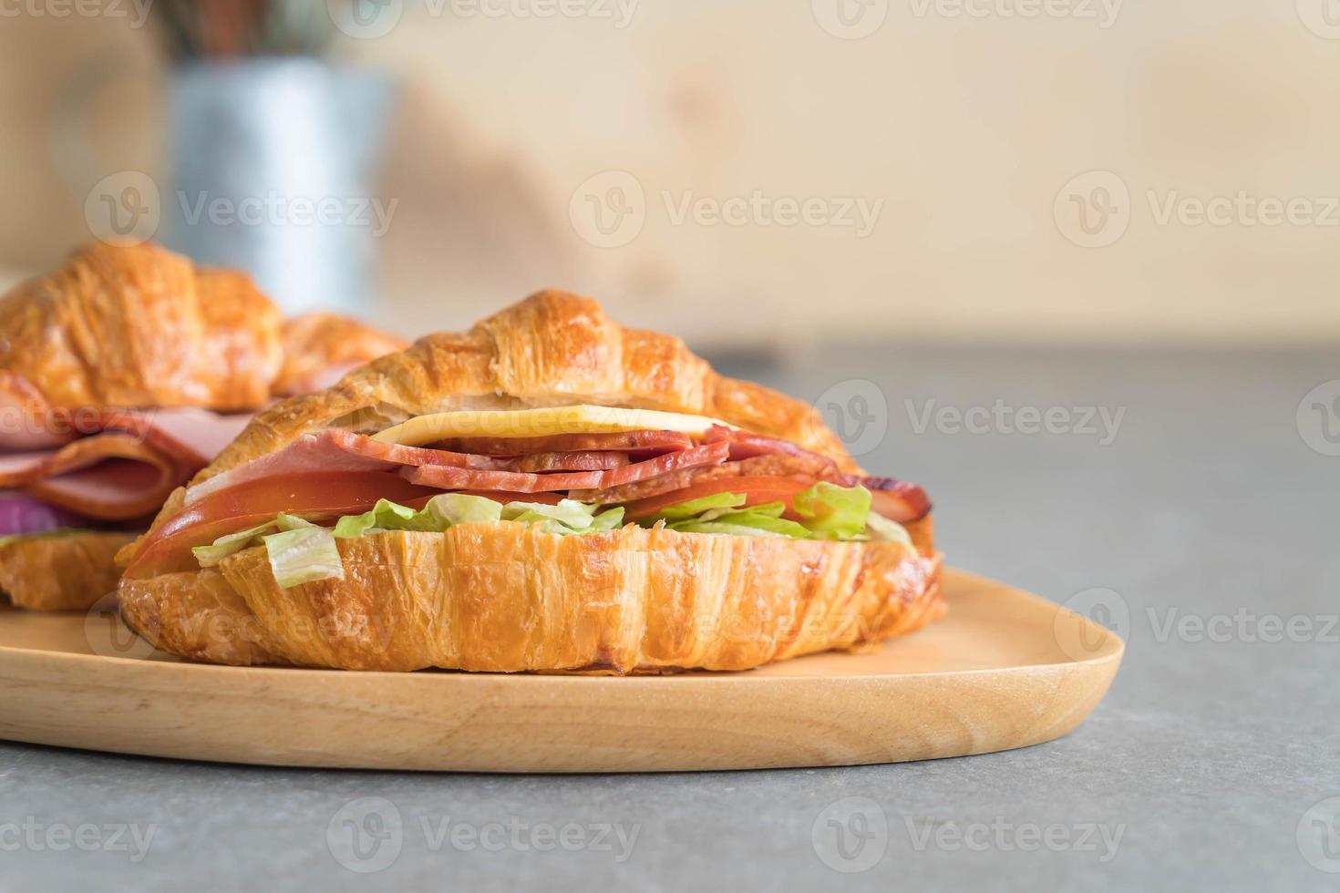 Jamón sándwich croissant en la mesa foto