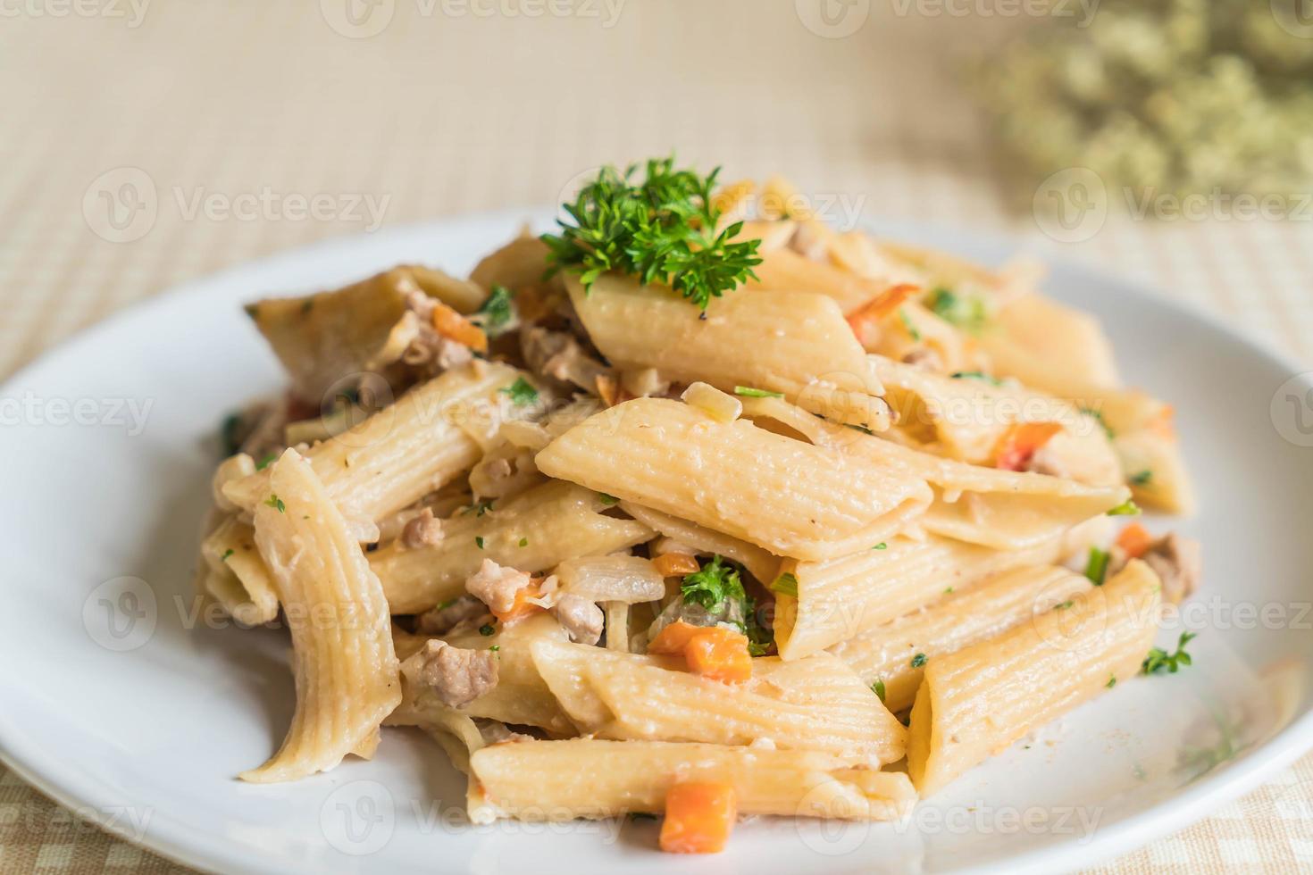 Pasta penne con queso crema en la mesa foto