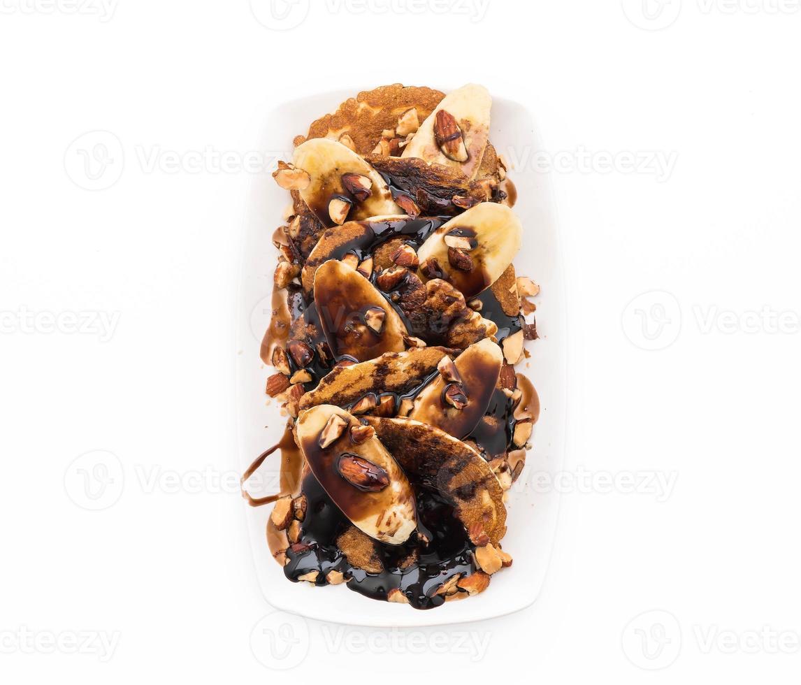 Almond banana pancake with chocolate syrup on white background photo