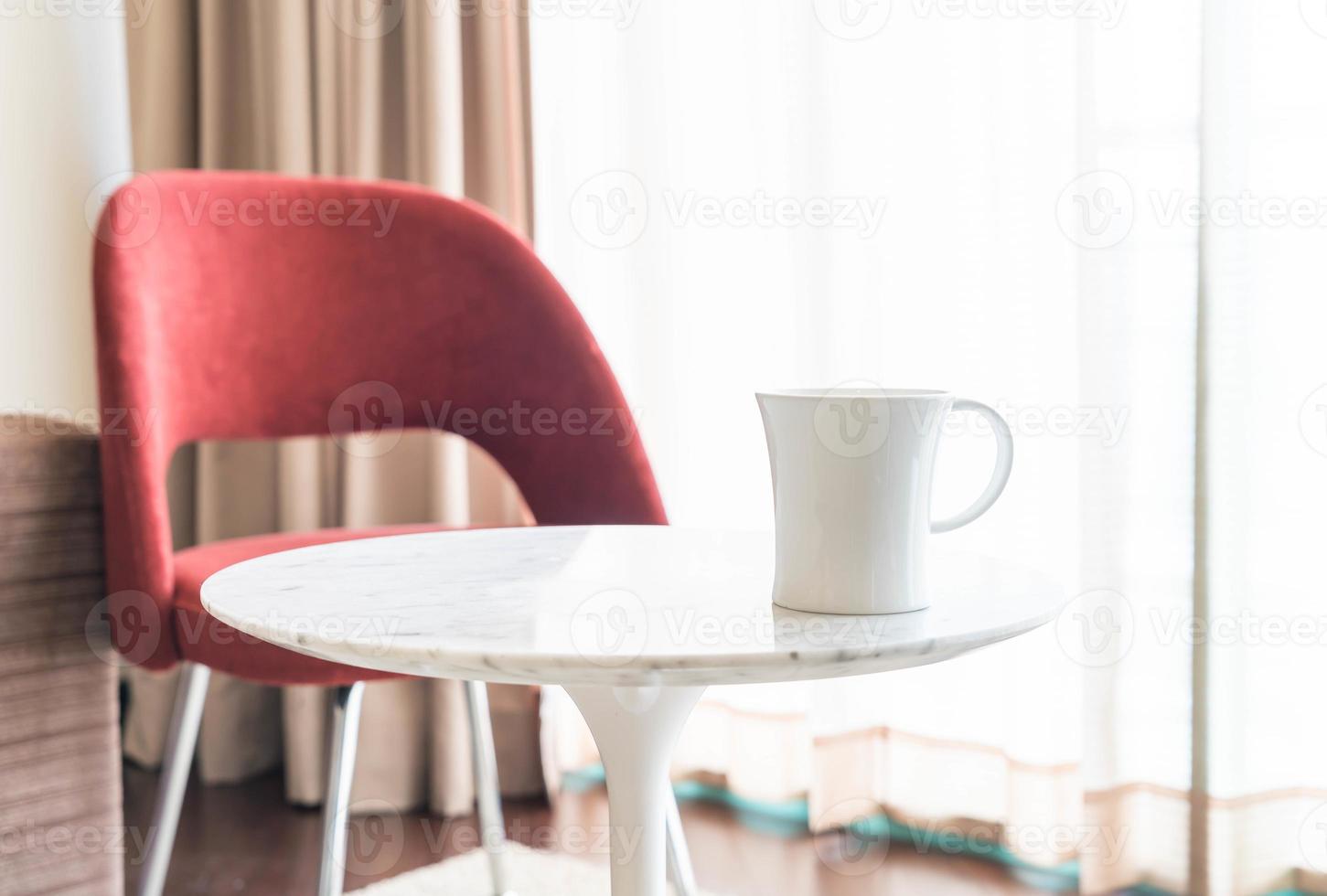Taza de café con una hermosa decoración de sillas y mesas de lujo en el interior del salón para el fondo - filtro vintage foto