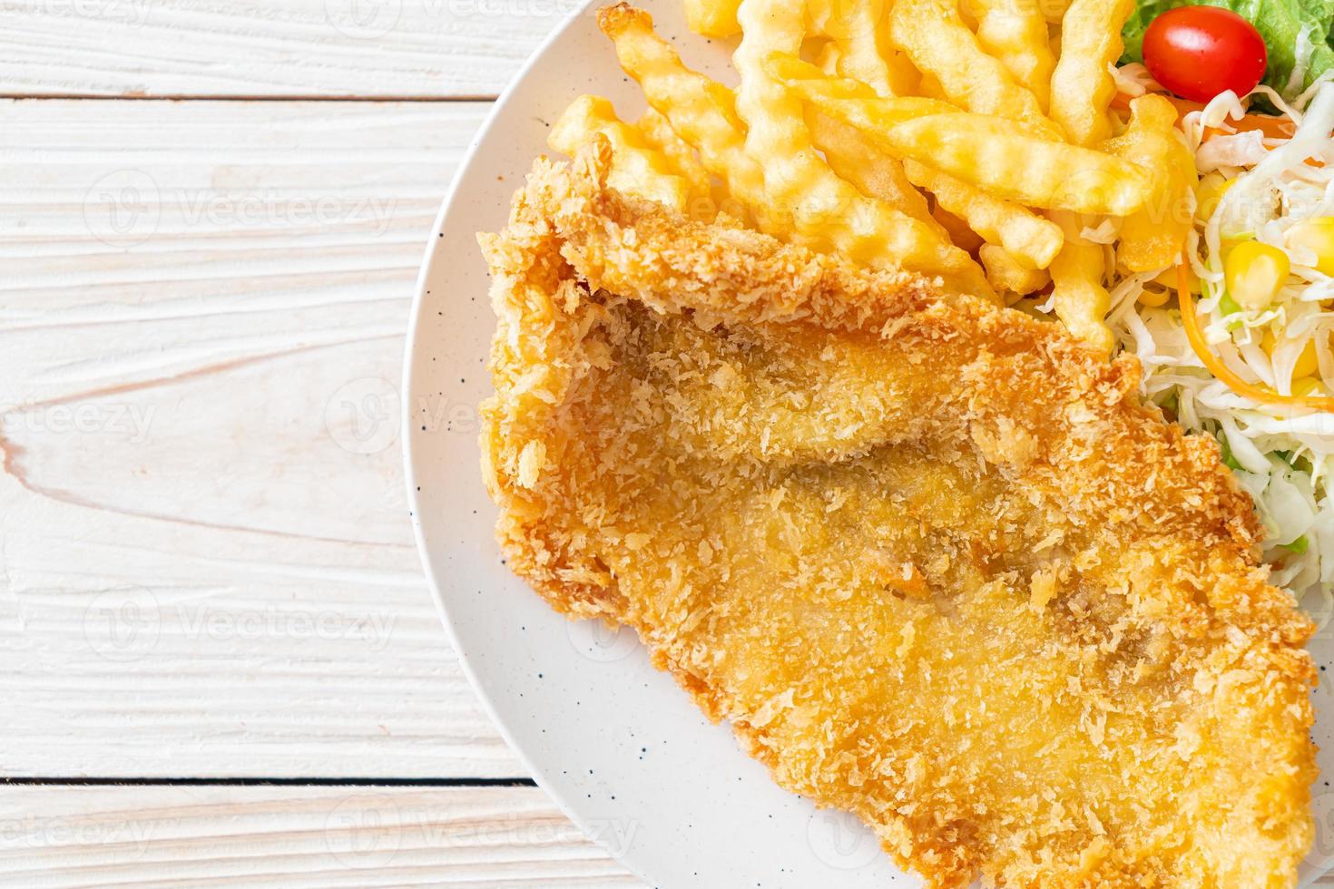 Fried fish fillet and potatoes chips with mini salad photo