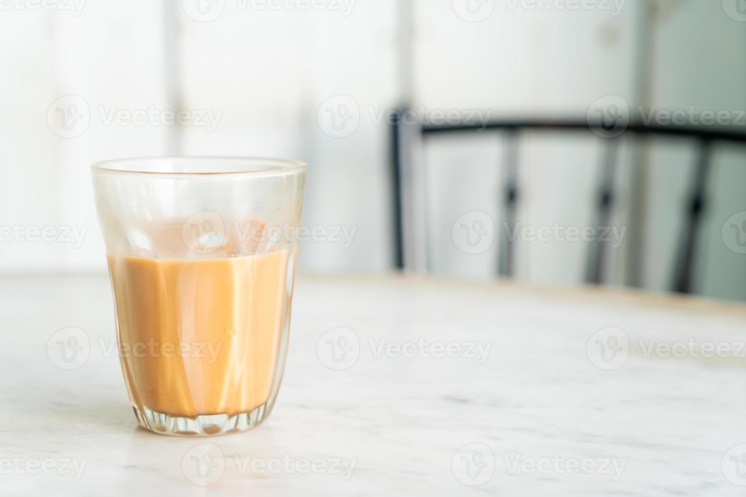 Hot Thai milk tea glass on table photo