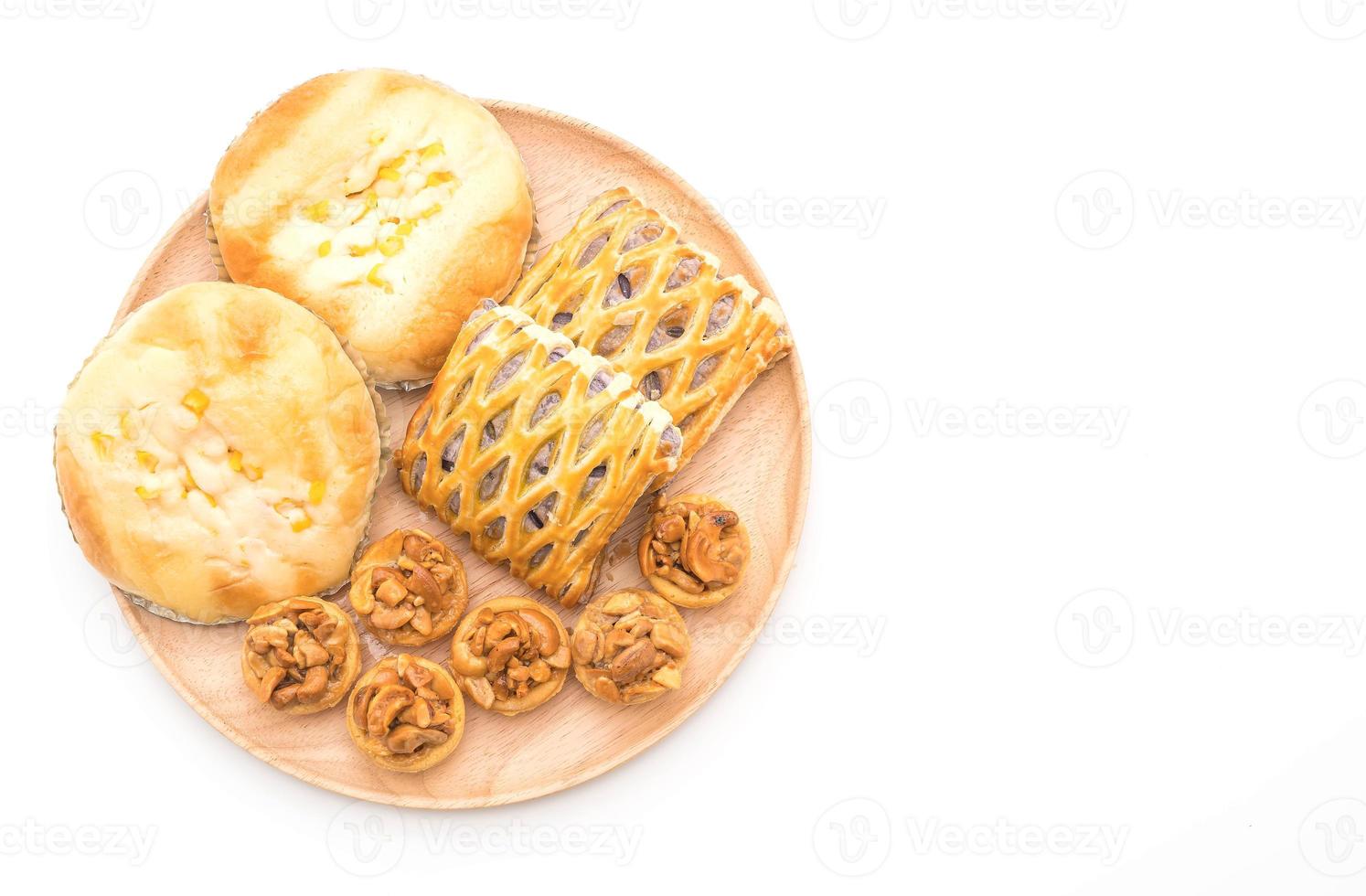 Toffee cake, bread with corn mayonnaise, and taro pies on white background photo