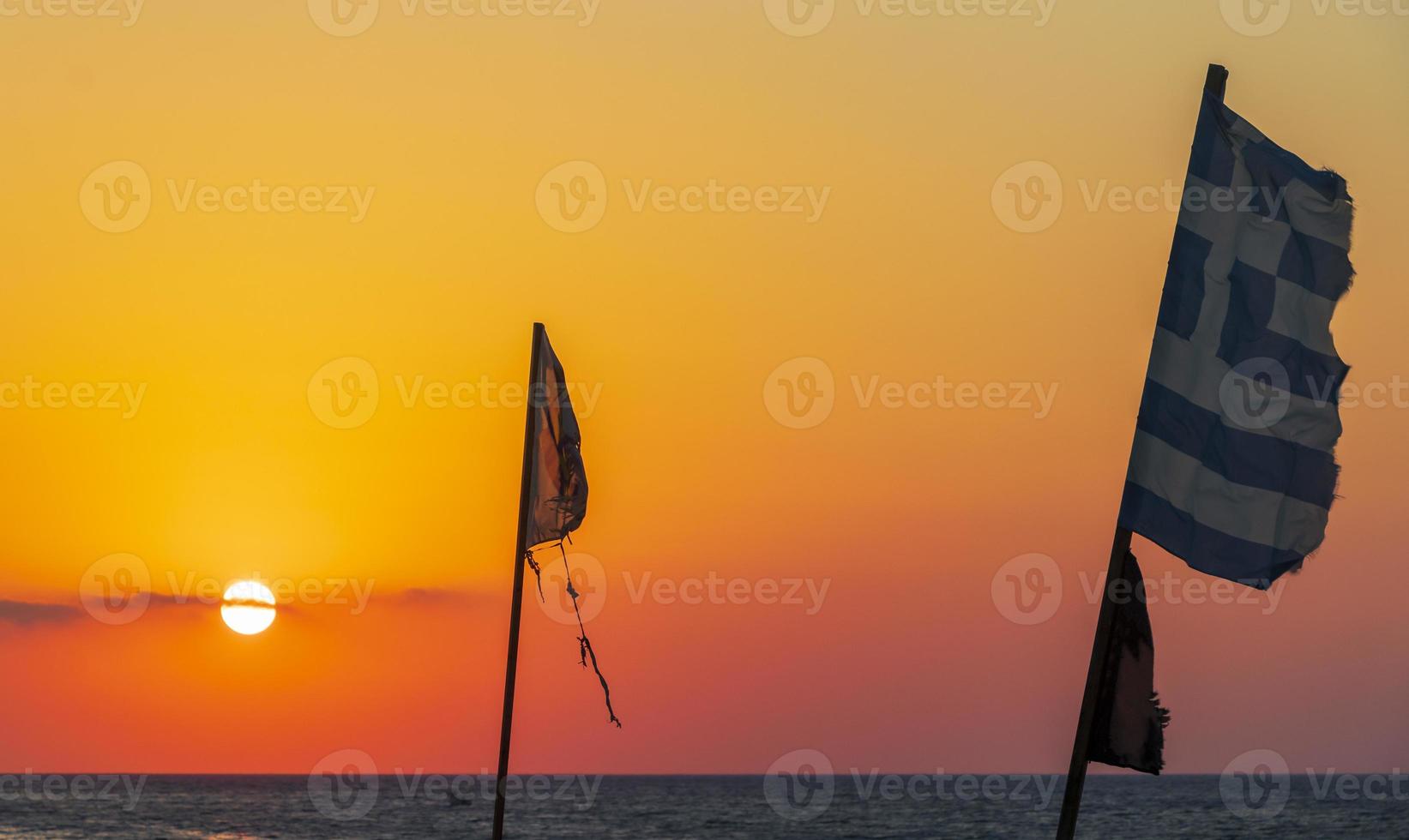 banderas en la más hermosa puesta de sol playa de ialysos rodas grecia. foto