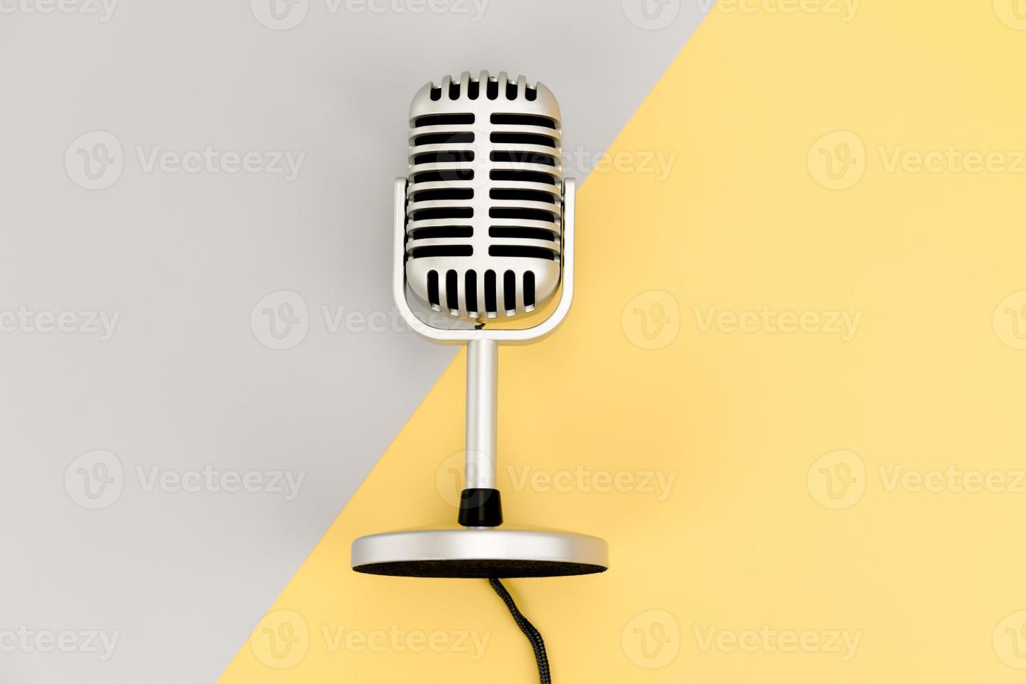 Top view Retro microphone with copy space on grey and yellow photo