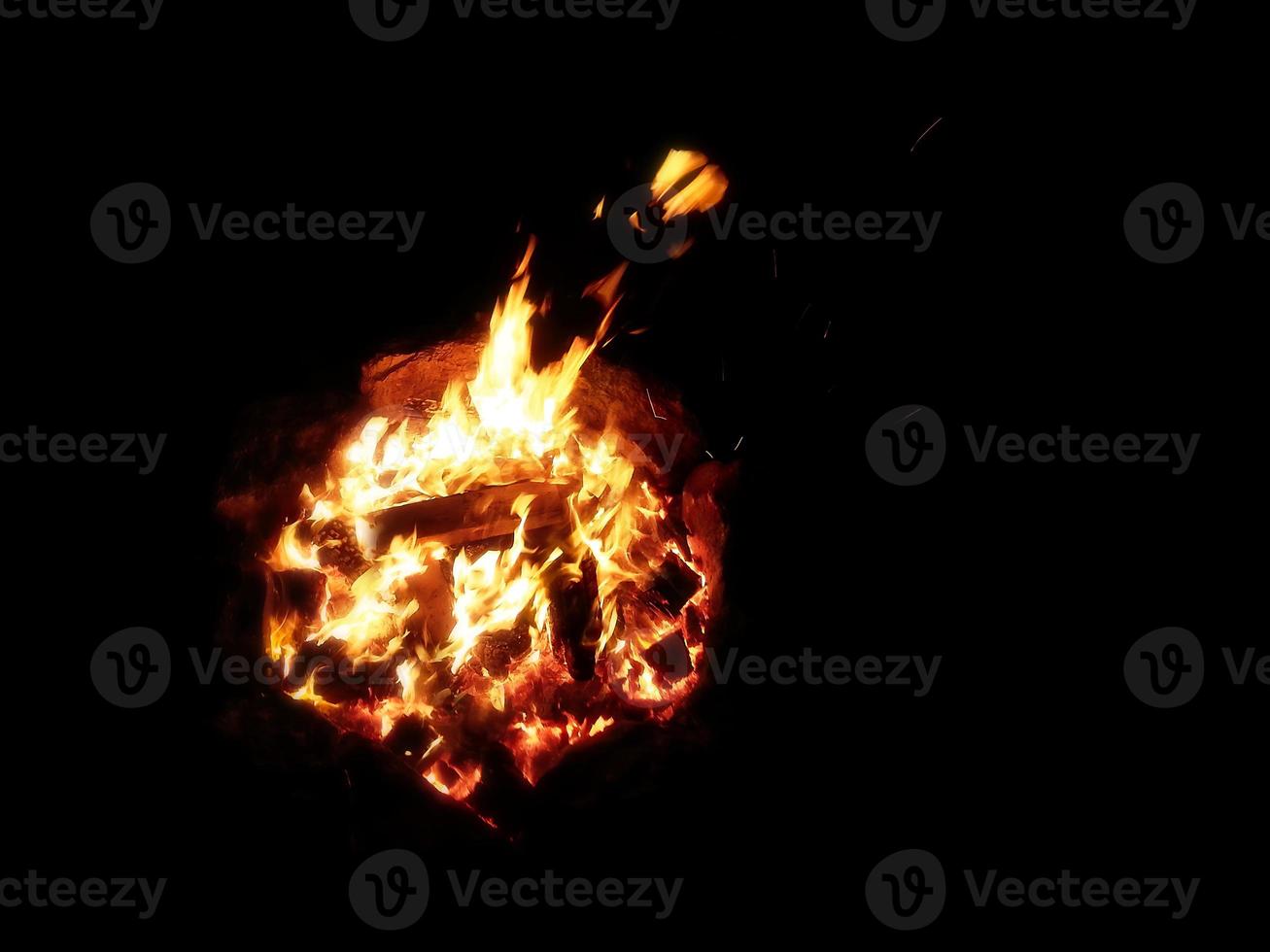 View from above of a bonfire and sparks are flying towards the camera photo