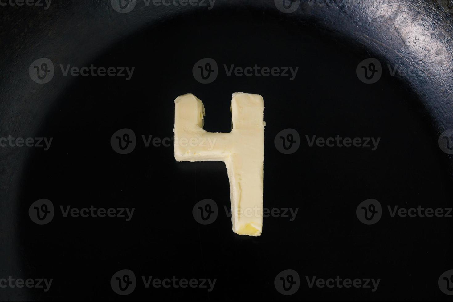 Butter in shape of number 4 on hot pan - Close up top view photo