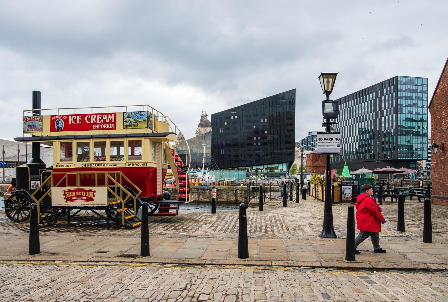 Un transeúnte y una clásica furgoneta de helados en los muelles de Liverpool, el puerto de Liverpool, Reino Unido foto