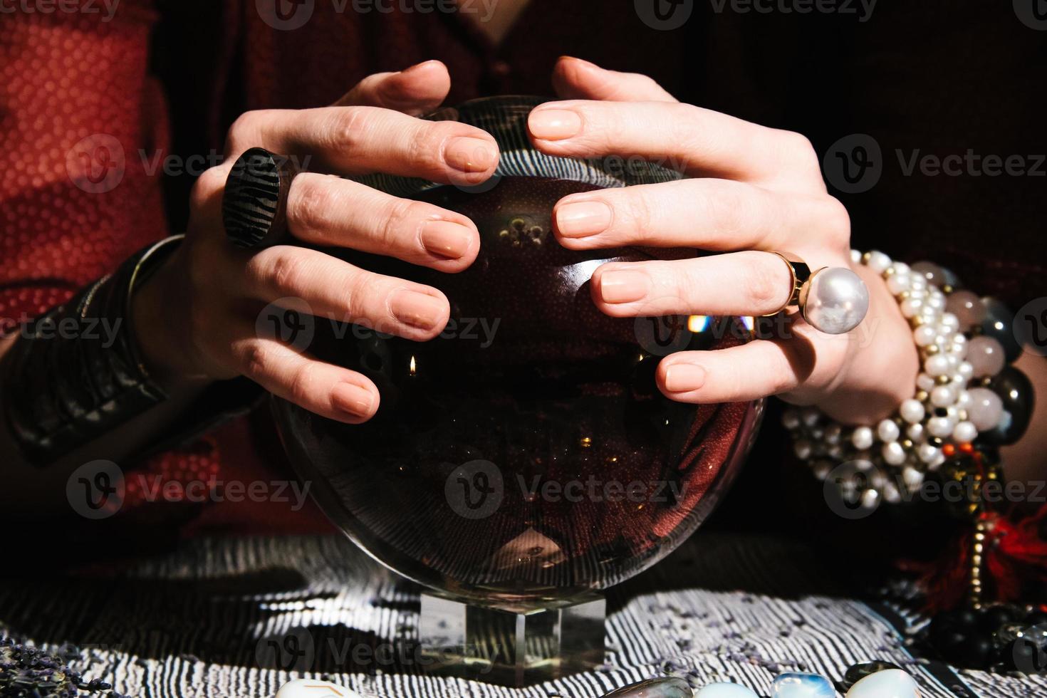 Primer plano de las manos del adivino en un orbe de cristal. interior místico foto