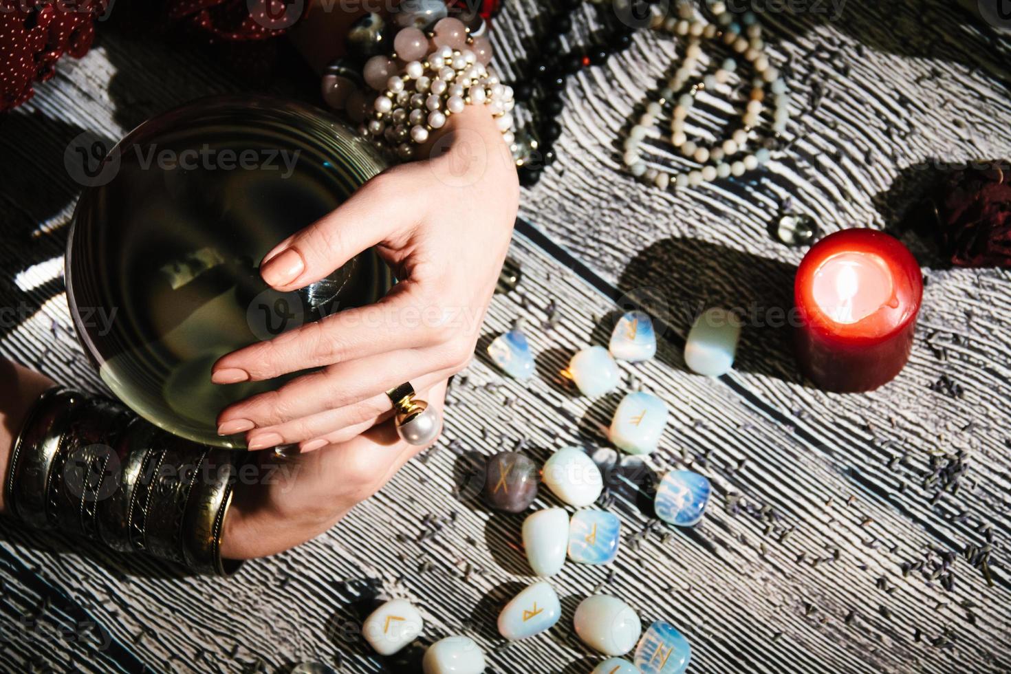 Fortuneteller's hands on a glass orb.  Mystic interior. Occult symbols photo