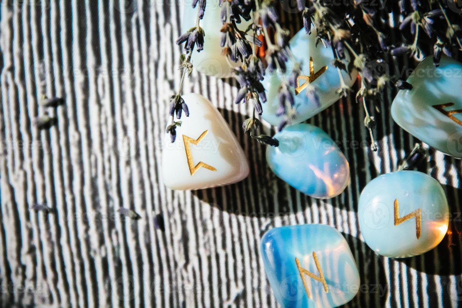 Close up of wooden table with occult attributes. Rune stones photo