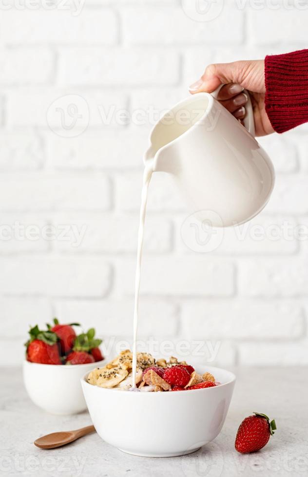 cereal, fresas frescas y leche en un bol foto