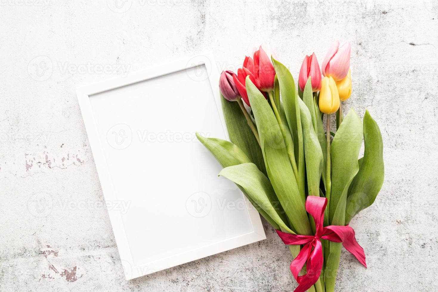 Ramo de tulipanes y marco en blanco para maqueta de diseño sobre fondo blanco. foto