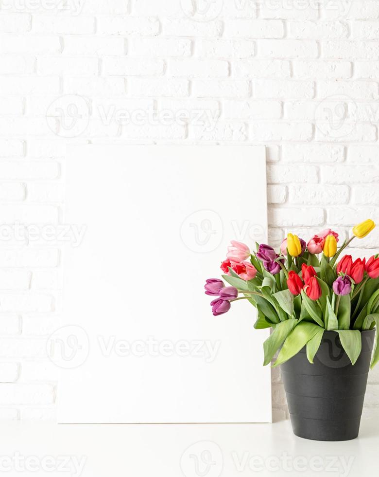 Mock up with Frame and bucket of tulips on white brick wall background photo